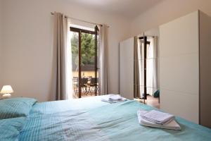 a bedroom with a blue bed and a window and a table at Apartments Galboka in Nerezine