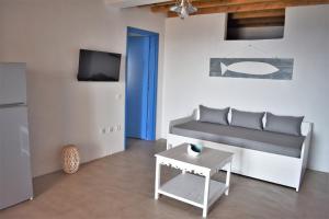 Arsinoi Apartments في سيريفوس شورا: غرفة معيشة مع أريكة وطاولة