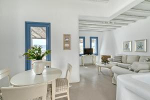 a white living room with a table and a couch at Mykonos Panormos Villas in Mykonos