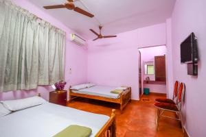 a room with two beds and a tv and a mirror at Sri Udupi Hotel in Trivandrum