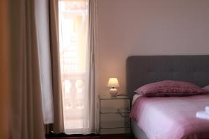a bedroom with a bed and a window with a lamp at Apartments Galboka in Nerezine