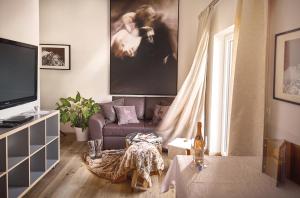 ein Wohnzimmer mit einem Sofa und einem TV in der Unterkunft KitzHome City Apartments in Kitzbühel
