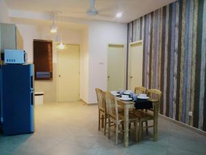 a dining room with a table and chairs and a refrigerator at SinggahSini Suite @ Atlantis Residences in Melaka