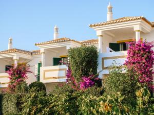 a white house with pink flowers in front of it at Vale d'El Rei Hotel & Villas in Carvoeiro