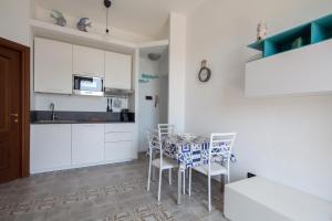 a kitchen with white cabinets and a table and chairs at Punti di Vista in Portovenere