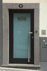 uma porta de vidro de um edifício com um sinal de vinho em The Wine Lodges no Funchal