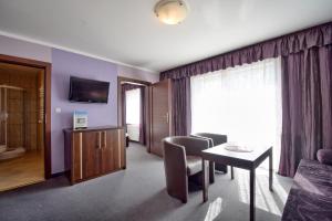 a hotel room with a table and chairs and a window at Lazur Wellness@Spa in Międzywodzie