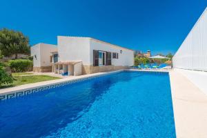 una villa con piscina di fronte a una casa di Villa Divina a Colonia de Sant Pere