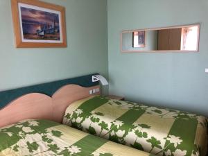 Dormitorio pequeño con cama y espejo en Hôtel Restaurant de L'Europort en Saint-Avold