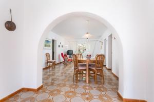 a dining room and living room with a table and chairs at Casa Fiol in Cala d´Or