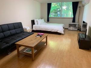a living room with a couch and a bed at Hana Yuki 103 in Furano