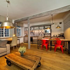 a living room with a table and red chairs at Patio Apartments - Old Town in Gdańsk