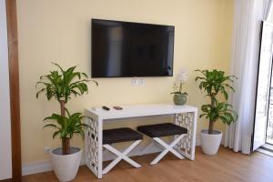 a table with a television and a vase on it at Lx Flowers Apartments in Lisbon