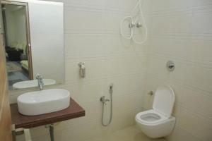 a bathroom with a toilet and a sink at Krishna Villa in Badami