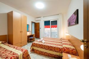 a hotel room with two beds and a window at Hotel Stoccarda in Caorle