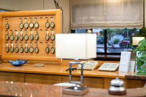 un bureau dans un magasin avec une lampe et un téléphone dans l'établissement Hotel Stoccarda, à Caorle