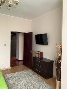 a living room with a television on a wall at Grand Eforie Apartment in Eforie Nord