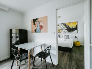Habitación con mesa, sillas y cama en SoYa Apartment Hotel, en Melbourne