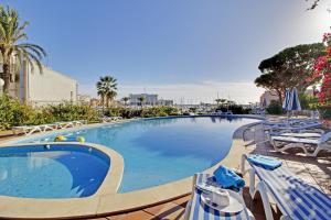 a large swimming pool with chairs and umbrellas at Marina Princess in Vilamoura