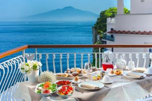 a table with food and the ocean in the background at Sorrento Dream in Sorrento