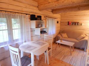 uma sala de estar com uma mesa e um sofá em Haaviku Nature Cottage em Tepelvälja
