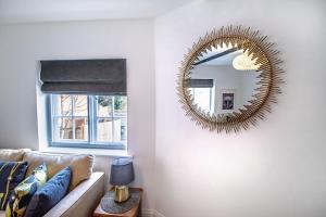a mirror on a wall in a living room with a couch at Little George in Henley in Arden