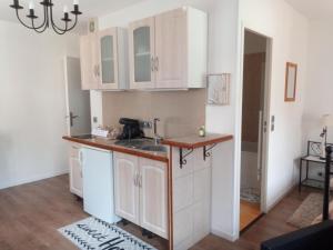 a kitchen with white cabinets and a counter top at Résidence Park de Vincennes in Pau