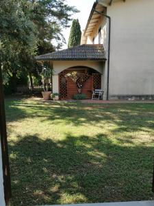 un cortile con un edificio e una sedia di Agriturismo Pettinari a Marina di Grosseto