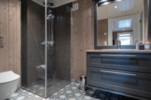 ein Bad mit einer Dusche, einem WC und einem Waschbecken in der Unterkunft Tinden Grendehytte in Beitostøl