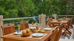 - une table en bois avec de la nourriture et des boissons sur une terrasse dans l'établissement Scardona Park Luxury Accommodation, à Skradin
