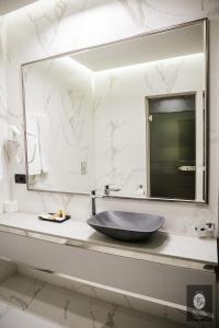 
a bathroom with a sink and a mirror at VisPas Hotel in Chişinău
