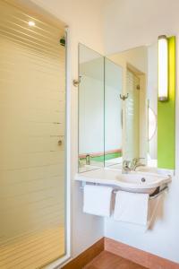 La salle de bains est pourvue d'un lavabo et d'un miroir. dans l'établissement ibis budget Cavaillon, à Cavaillon