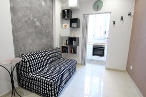 a living room with a black and white chair and a window at Rosemary Charming Rooms in Termoli