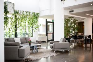 a lobby with couches and chairs and a table at Airporthotel Verona Congress & Relax in Dossobuono