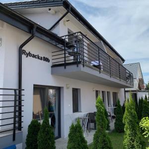 a house with a balcony and a patio at Pensjonat SYRENA in Krynica Morska