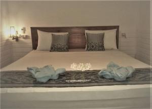 a bedroom with a bed with two towels on it at Balakosa Gili Meno Bungalow in Gili Meno