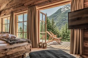 a bedroom with a large window with a view of a mountain at Benglerwald Berg Chaletdorf in Bach