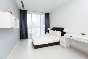 a white bedroom with a bed and a desk at Binjai 8 KLCC by PSM Luxury Suites in Kuala Lumpur