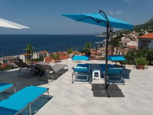 a patio with blue tables and chairs and an umbrella at Villa Blue View in Sumpetar