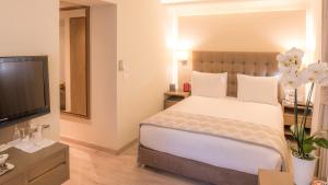 a bedroom with a bed and a flat screen tv at InterContinental Mzaar Lebanon Mountain Resort & Spa, an IHG Hotel in Kfardebian
