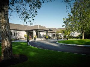 a house with a tree and a winding road at Fitzgeralds Woodlands House Hotel in Adare