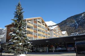 ein Weihnachtsbaum vor einem Gebäude in der Unterkunft Haus Viktoria A in Zermatt