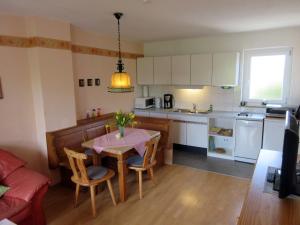 una pequeña cocina con mesa y sillas en una habitación en Gästehaus zur Brücke en Waging am See