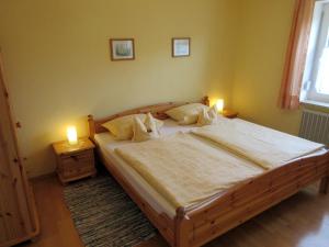 1 dormitorio con 1 cama grande de madera y 2 lámparas en Gästehaus zur Brücke en Waging am See