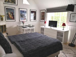 a bedroom with a bed and a desk and a television at Lovely Mint Garden Studio in Vantaa