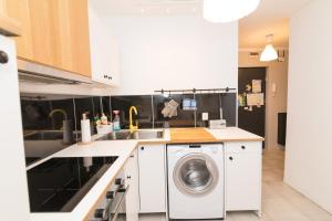 a white kitchen with a washing machine in it at Apartament Pomorski in Hel