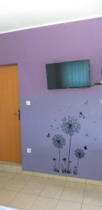 a purple wall with dandelions painted on it at Apartment Marko in Šibenik