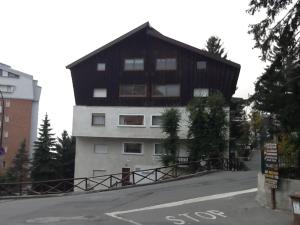 a large building with a black roof on a street at SAUZE 50 MT PISTE CLOTES in Sauze dʼOulx