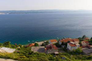 an aerial view of a house on a hill next to the water at Apartments Drago Kovačić in Omiš