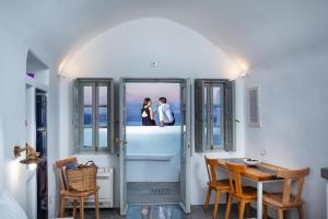 two people standing on the balcony of a house at Diamond Luxury Suites in Oia